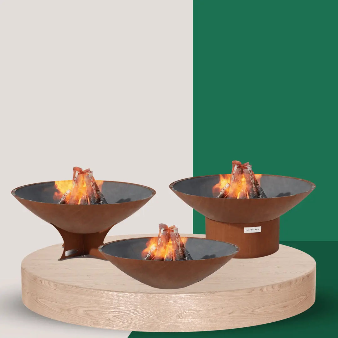 Arteflame fire pits collection with corten steel bowl fire pits in various sizes featuring wood-burning flames for outdoor living spaces.