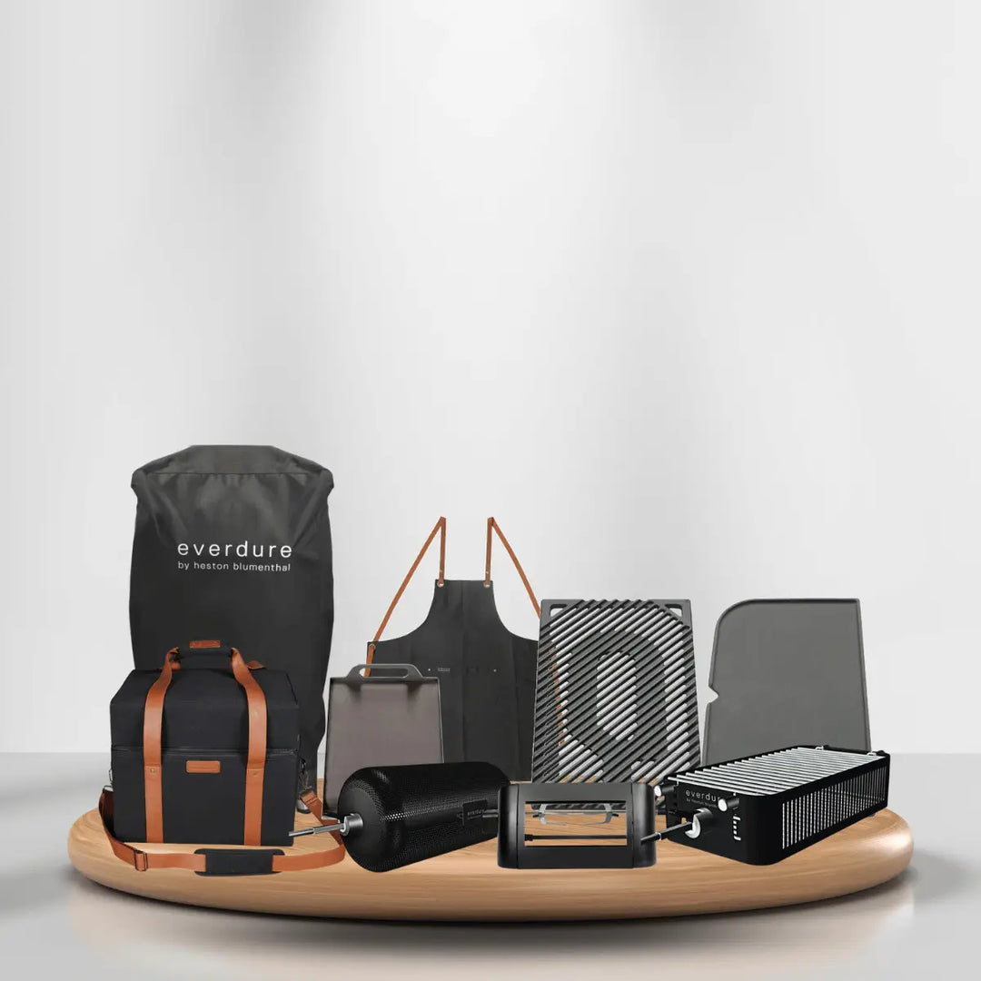 Everdure grilling accessories collection with apron, grill grates, rotisserie, cooler bag, and cooking tools on modern display platform.