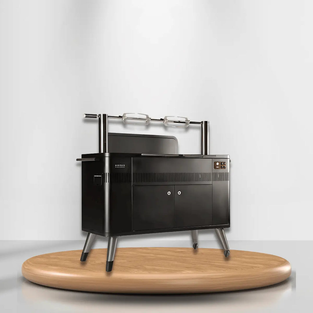 Everdure outdoor BBQ grill with rotisserie, storage cabinet, and sleek black design on wooden platform for modern outdoor cooking setup.