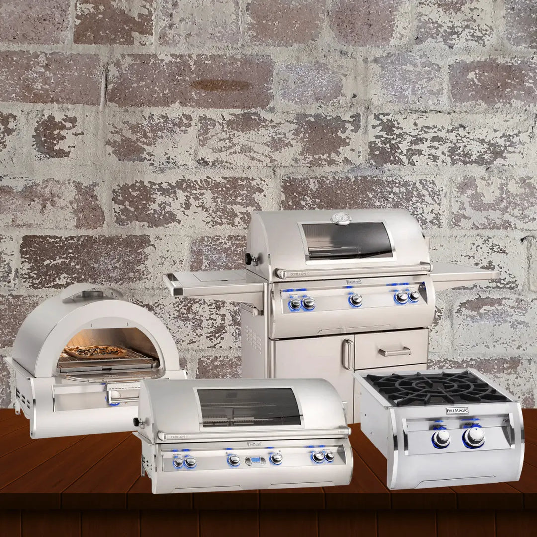 Fire Magic Echelon collection featuring premium stainless steel gas grills, built-in grill units, side burner, and outdoor pizza oven displayed on a wooden surface with a rustic brick wall background.