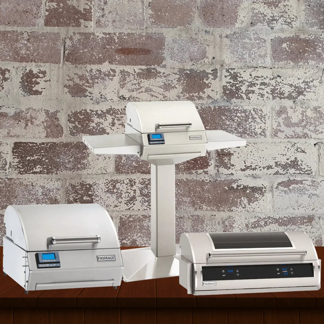 Fire Magic electric grills collection featuring compact stainless steel electric grills, including portable countertop and pedestal-mounted models with digital controls, displayed against a rustic brick wall background.