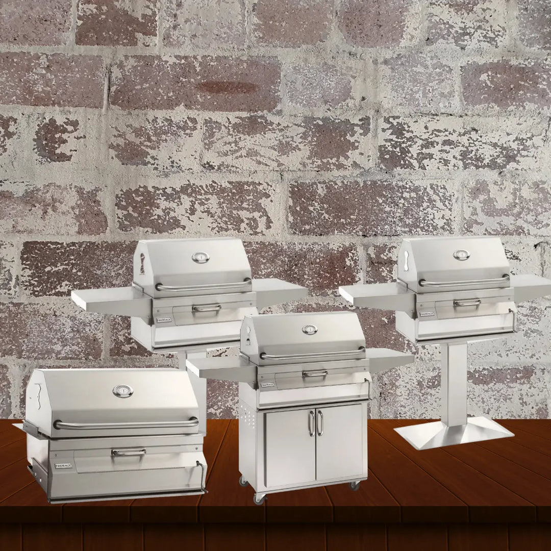 Fire Magic stainless steel charcoal grills collection featuring compact charcoal grills in built-in, cart, and pedestal models with side shelves, displayed on a wooden surface with a rustic brick wall background.