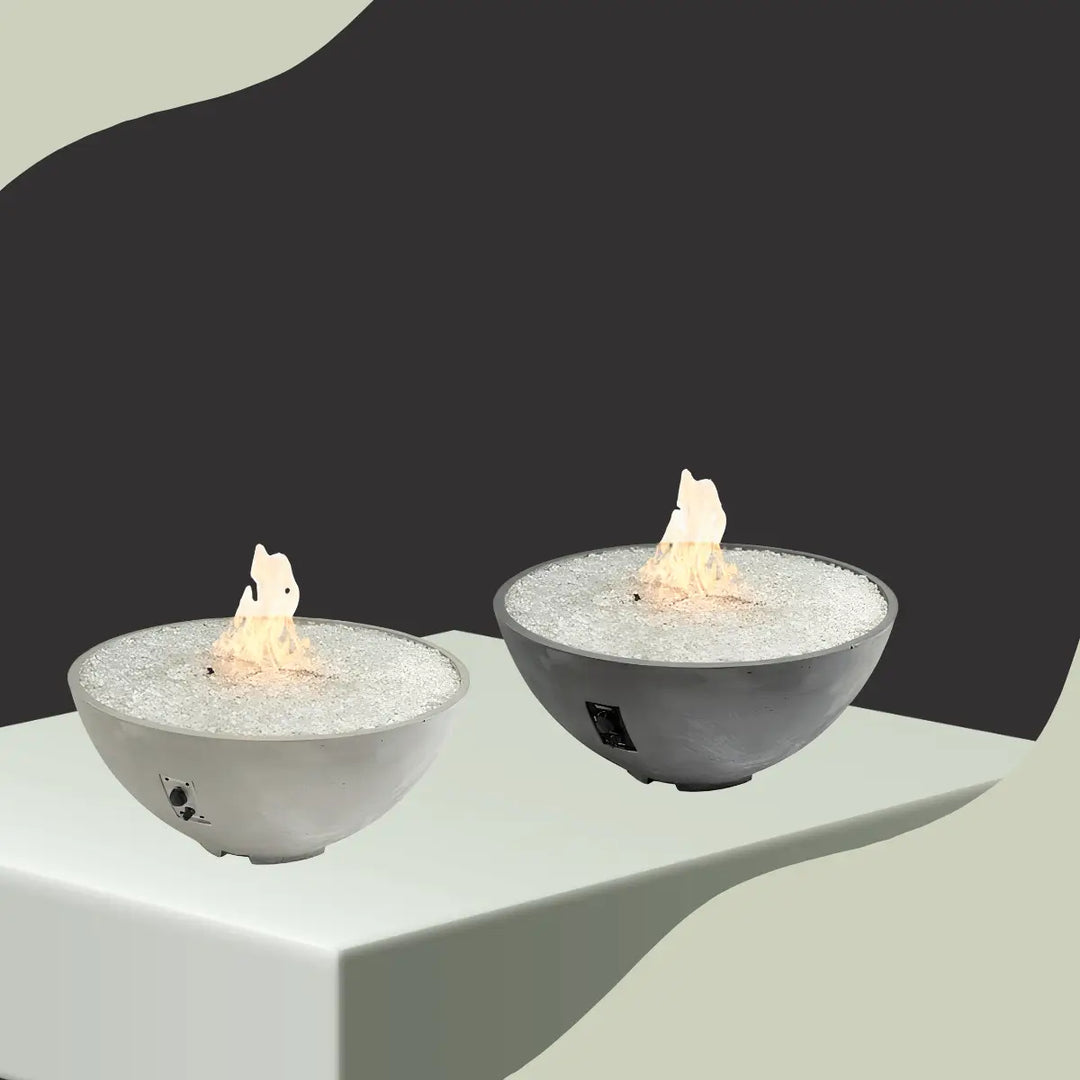 The Outdoor GreatRoom Cove Edge fire bowls collection featuring round concrete gas fire pits with white fire glass and modern outdoor design.