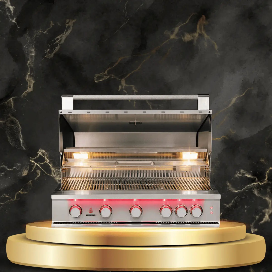 TrueFlame stainless steel outdoor grill with open lid, illuminated control knobs, and spacious cooking grates on luxury display platform