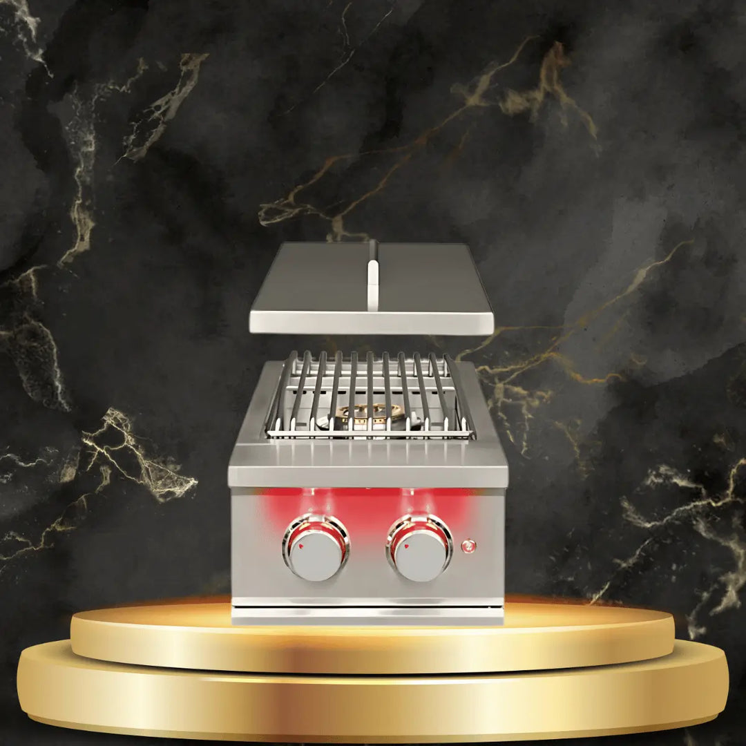 TrueFlame side burner with stainless steel design, dual control knobs, and open lid displayed in a luxury outdoor kitchen setting.